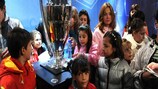 Children cluster round the UEFA Champions League trophy in Sofia