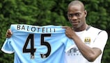Mario Balotelli shows off the colours of his new club after being unveiled as a Manchester City player