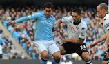 City's Carlos Tévez (left) and Clint Dempsey of Fulham vie for possession