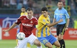 Radosław Sobolewski of Wisła (left) fights for a ball with APOEL's Hélio Pinto during the first leg