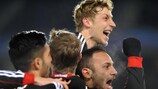 Os jogadores do Leverkusen abraçam Ömer Toprak após o defesa fazer o golo da vitória