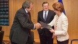 Michel Platini (à gauche) et Androulla Vassiliou se serrent la main, sous le regard de José Manuel Barroso