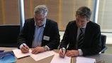 El secretario general del INCIS Harri Syväsalmi (izquierda) y Marc Vouillamoz (UEFA) han firmado un acuerdo