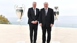 Karl-Erik Nilsson (left) and Karl-Heinz Lambertz, flanked by the UEFA Champions League (left) and UEFA EURO trophies