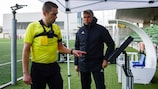 Finnish referee Mattias Gestranius consults the screen to review an incident, alongside UEFA chief refereeing officer Roberto Rosetti