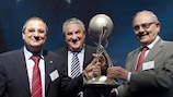 Председатель Комитета УЕФА по детско-юношескому и любительскому футболу Джим Бойс вручает трофей Мориса Бурлаза Хинесу Мелендесу (слева) и Висенте Муньосу Кастельо (справа)