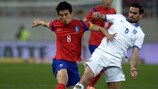 Полузащитник сборной Южной Кореи Ко Джа Чхоль в борьбе за мяч с Александросом Циолисом