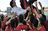 Os jogadores de Gibraltar celebram com o seleccionador Allen Bula depois do primeiro triunfo