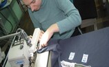 An employee at Socium Plus works on clothing for the Respect Inclusion campaign