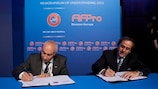 O Presidente da UEFA, Michel Platini, e o presidente da Divisão Europa da FIFPro, Philippe Piat, assinam o Memorando de Entendimento
