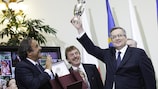 Polish President Bronisław Komorowski raises a replica of the Henri Delaunay Cup