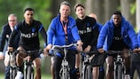 Dutch coach Louis van Gaal gets on his bike, flanked by members of his squad