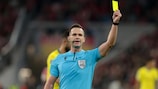 O árbitro Ivan Kružliak exibe um cartão amarelo durante a fase de grupos da UEFA Champions League 2022/23 