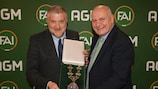 Paul Cooke, left, takes the FAI presidential chains from outgoing president Gerry McAnaney, right