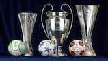 Los tres trofeos de las competiciones masculinas de clubes de la UEFA, junto con sus tres balones oficiales